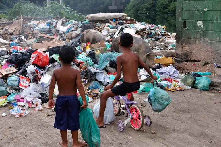 Crianças brincando descalças em terreno de terra batida