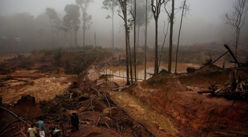 Descreva a cena: área de garimpo com cavas de água parada na Amazônia