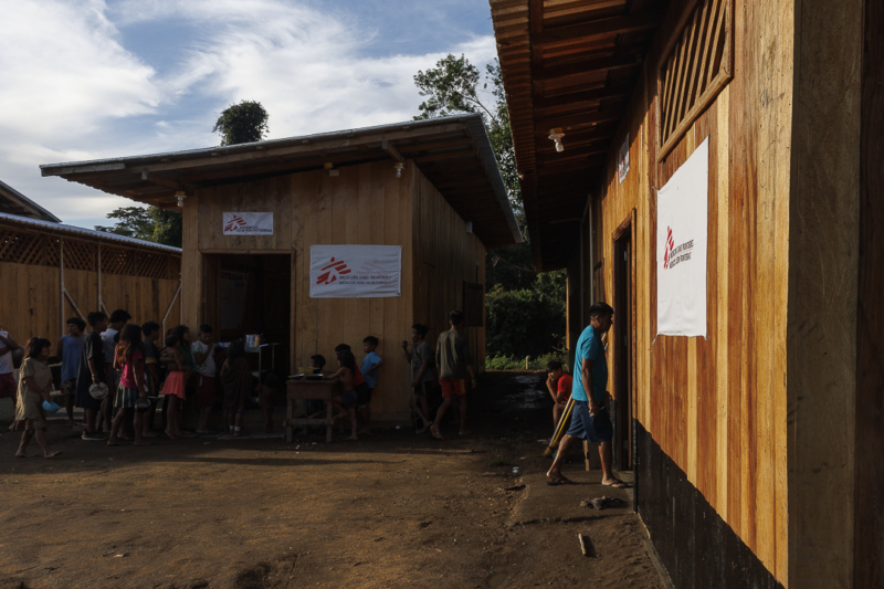 Descreva a cena: atendimento de saúde em comunidade indígena da Amazônia
