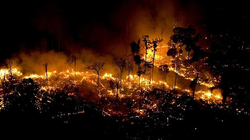 Coluna de fumaça de queimada em área de floresta durante período de seca