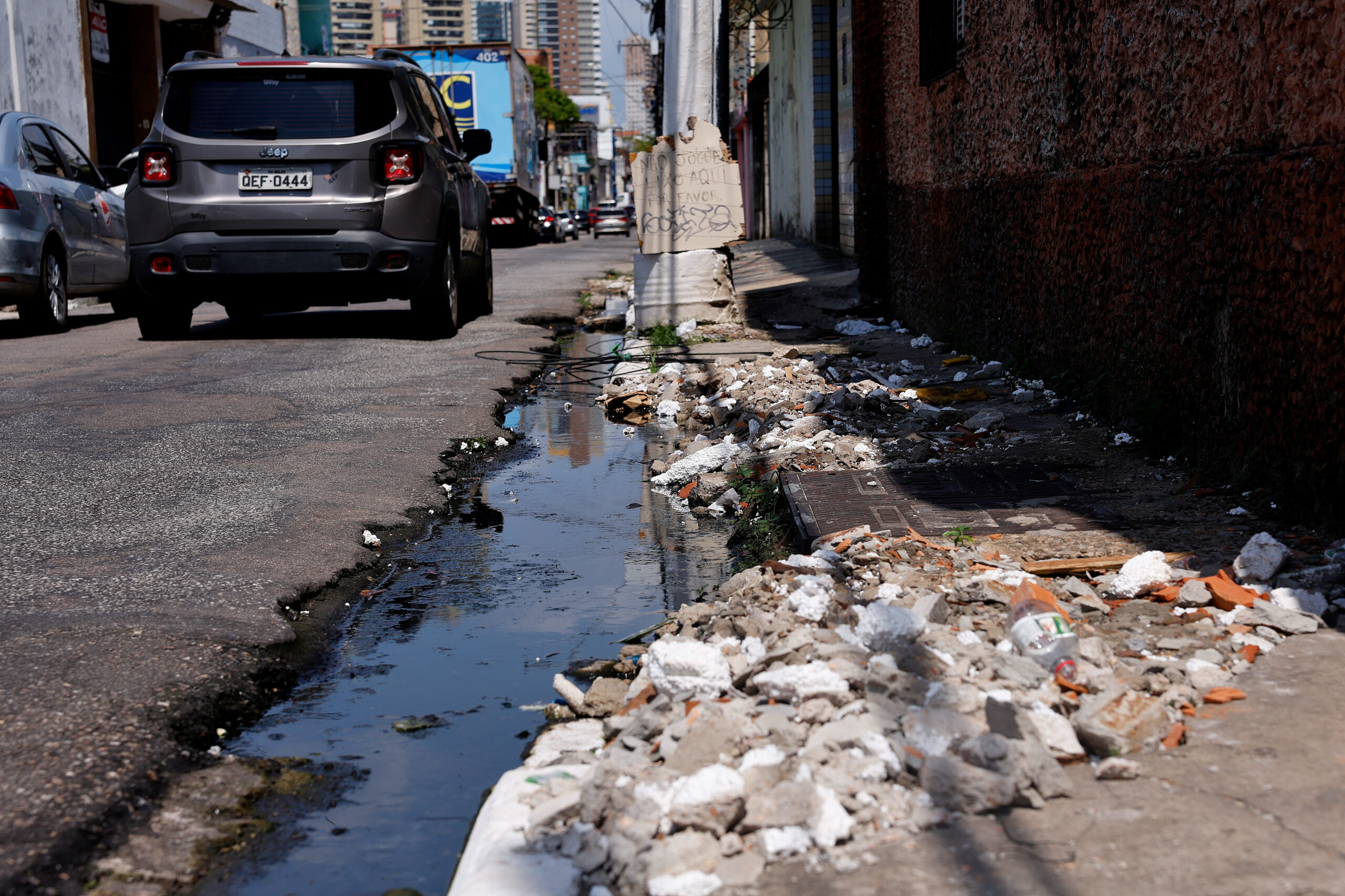 Esgoto a céu aberto em área urbana, mostrando a relação entre saneamento precário e transmissão de doenças