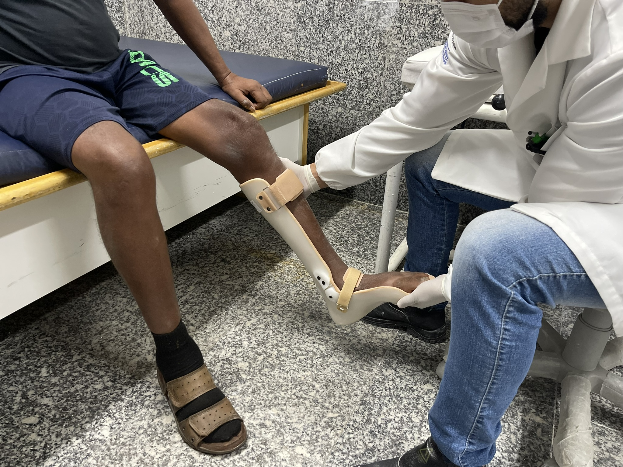 Órtese de posicionamento para mão em garra e faixas elásticas de reabilitação dispostas sobre mesa de terapia ocupacional